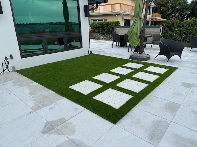 A beautiful synthetic grass front yard with a clean, green lawn that frames a modern home. The turf is perfectly manicured, showing its low-maintenance and polished appearance. 