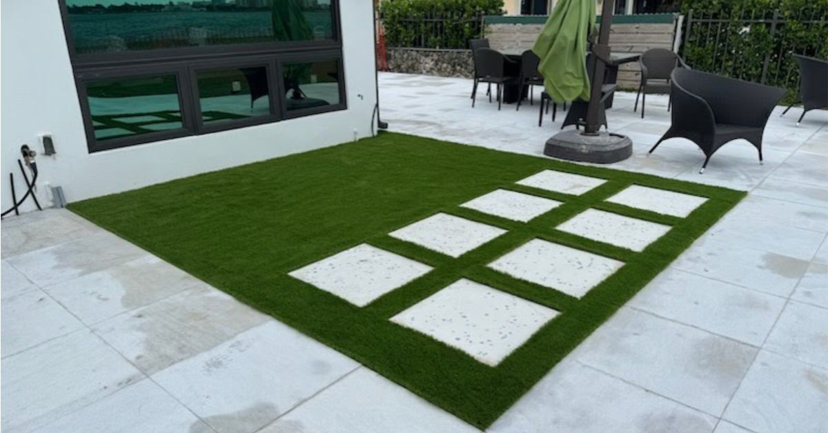 Homeowner using a pet-safe enzyme spray to clean dog urine from fake grass.