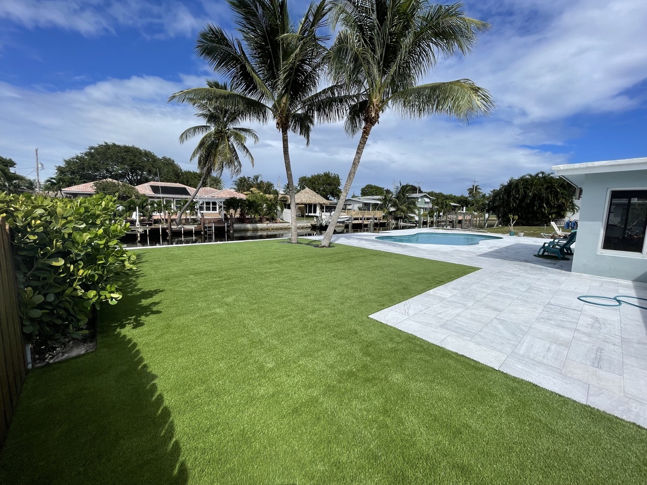 Artificial turf installation adjacent to paver patio installation